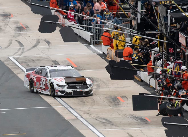 Corey LaJoie heads to his pit box to have his hood repaired at the Drydene 400 - Monster Energy NASCAR Cup Series playoff auto race, Sunday, Oct. 6, 2019, at Dover International Speedway in Dover.