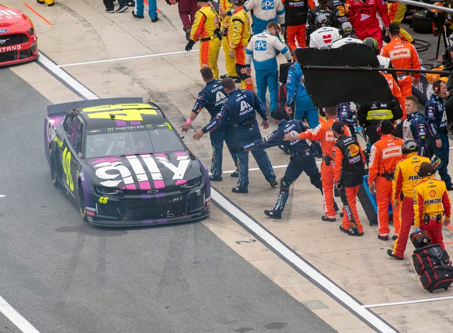 Jimmie Johnson's team puts out their hands as he leaves pit road for the start of the Drydene 400 - Monster Energy NASCAR Cup Series playoff auto race, Sunday, Oct. 6, 2019, at Dover International Speedway in Dover.