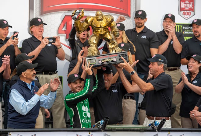 Kyle Larson, front left center, gets help in holding up the trophy after his win in the NASCAR Cup Series auto race Sunday, Oct. 6, 2019, at Dover International Speedway in Dover.