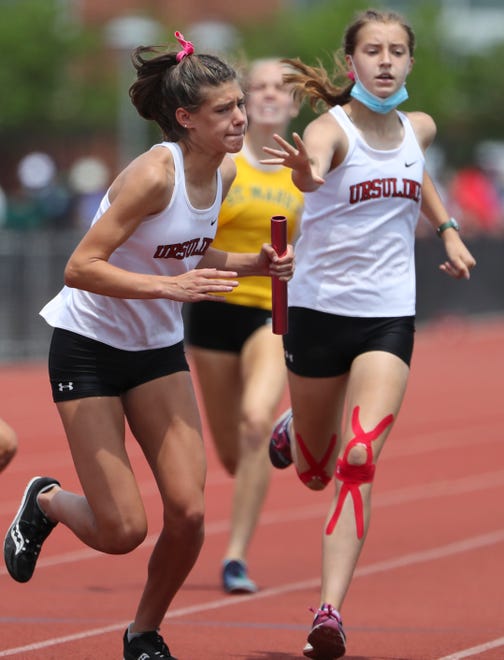 Ursuline's Emily Rzucidlo (left) takes the baton from Clare Kornacki as the Raiders win the Division II 4x400 meter relay race on the second and final day of the DIAA state high school track and field championships Saturday, May 22, 2021 at Dover High School.
