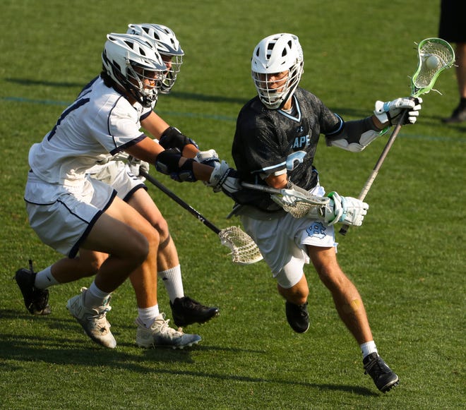 Cape Henlopen's Henry D'Ambrogi (right) looks to the net past Sanford's Ian Binnersley (left) and Andrew Taylor (obscured) in the first half of the Vikings' 16-15 win at Sanford School in a semifinal of the DIAA state tournament Tuesday, May 25, 2021.
