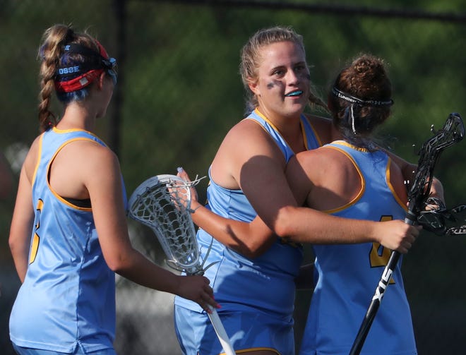 Cape Henlopen's Riley Keen (center) celebrates a goal in the first half of the DIAA state tournament title game Thursday, May 27, 2021 at Dover High School.