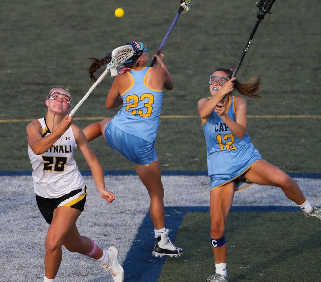 Tatnall's Teryn Singer (left) vies for a faceoff against Cape Henlopen's Molly Mendes (23) and Lindsay Rambo in the second half the Vikings' 17-10 win in the  DIAA state tournament championship game Thursday, May 27, 2021 at Dover High School.