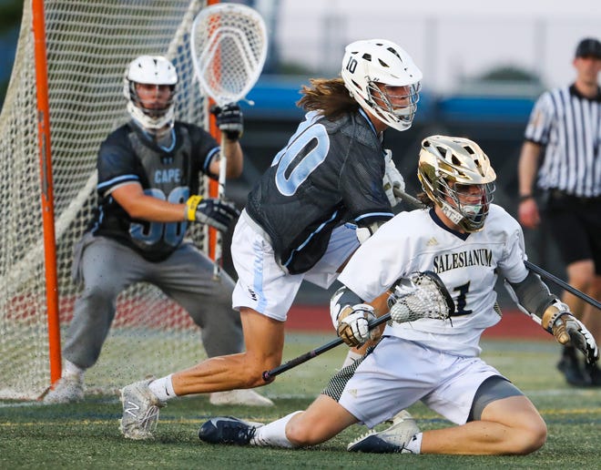Salesianum's Caelan Driggs falls but keeps possession of the ball before getting up and scoring in front of Cape Henlopen's Drew Dennis and goalie Michael Sposato in the first half of the DIAA state tournament championship game Thursday, May 27, 2021 at Dover High School.