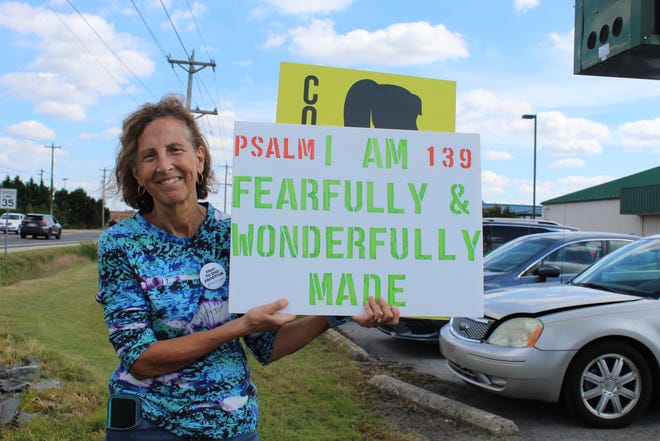 Joan Harper of Seaford shows her sign during the counter protest to the Women's March in Seaford on Saturday, Oct. 2, 2021.