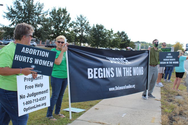 Sharon Williams of Ellendale holds a sign that says "Justice Begins in the Womb" alongside other protesters in opposition to abortions and Planned Parenthood in Seaford on Saturday, Oct. 2, 2021.